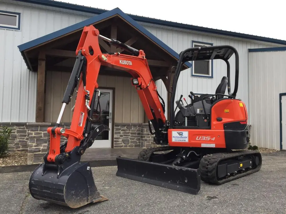 A kubota excuvator sitting in front of a building.
