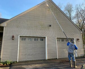 Washing house siding with pressure washer with extendable wand